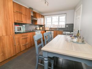 une cuisine avec des armoires en bois et une table avec des chaises dans l'établissement Armstrong Cottage, à Beverley 8 autres photos