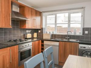 a kitchen with wooden cabinets and a stove top oven at Armstrong Cottage in Beverley