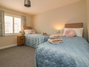 a bedroom with two beds with towels on them at Armstrong Cottage in Beverley
