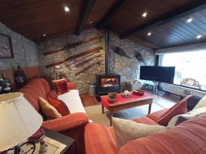 a living room with a couch and a fireplace at El Paller d'Urús in Urus