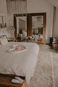a bedroom with a large white bed with flowers on it at Qambathi Mountain Lodge in Kamberg Valley