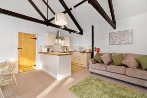 a living room with a couch and a kitchen at Daisy Cottage in Paignton