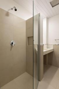 y baño con ducha y puerta de cristal. en Costa Norte Ponta das Canas Hotel, en Florianópolis