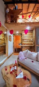 ラ・カレラにあるCabaña en la Calera el Pinarのソファ、テーブル(ワイングラス付)が備わる客室です。
