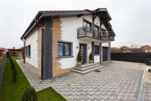 a white house with a balcony and a courtyard at Villa Montana in Braşov