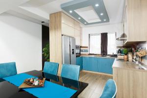 uma cozinha com uma mesa de jantar e cadeiras azuis em Villa Montana em Brasov