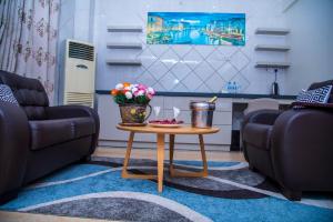 una sala de estar con dos sofás y una mesa con flores. en Lantana Hotel, en Dar es Salaam