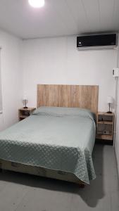 a large bed in a room with two night stands at TERRABOX Apart de contenedores in Olivera