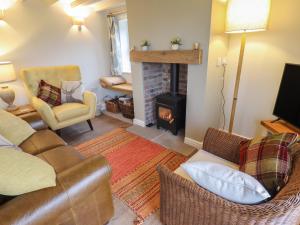 a living room with a couch and a fireplace at Shepherd's Cottage in Alford