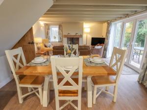 a dining room and living room with a table and chairs at Shepherd's Cottage in Alford +13 photos