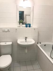 biała łazienka z toaletą i umywalką w obiekcie Čertovka Trojka - apartmán Harrachov w mieście Harrachov