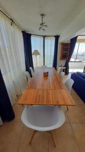 una mesa de madera y sillas en la sala de estar. en Dpto Concon, en Concón