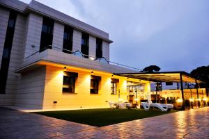 a building with two white benches in front of it at 6 Bis HOTEL in Castelldefels