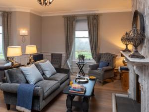 a living room with a couch and a fireplace at Oakdene Country House in Sedbergh