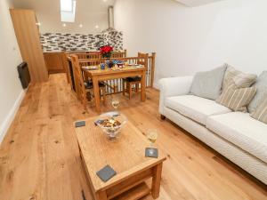 a living room with a couch and a table at Macaw Cottages, No 4 in Kirkby Stephen