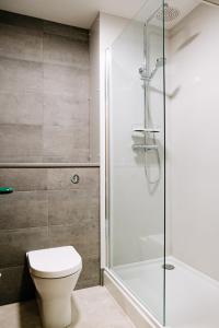 a bathroom with a toilet and a shower at National Badminton Centre Lodge & Health Club in Milton Keynes