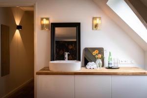 een badkamer met een wastafel en een spiegel bij Het Weeshuis in Bolsward