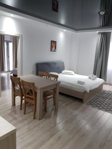 a room with two beds and a table and chairs at Happy Residence in Vişeu de Sus