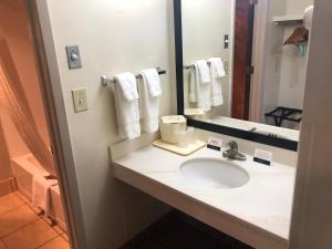 La salle de bains est pourvue d'un lavabo et d'un miroir. dans l'établissement NavajoLand Hotel, à Tuba City