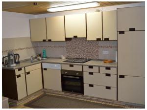 a kitchen with white cabinets and a stove top oven at Ferienwohnung Waldraff in Ostrach