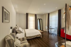 ein Hotelzimmer mit einem Bett und einem Stuhl in der Unterkunft Qui Vicino boutique rooms and suites in Trapani
