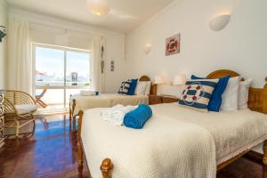 1 Schlafzimmer mit 2 Betten mit blauen und weißen Kissen in der Unterkunft Sunny Seaside Escape in Lagos