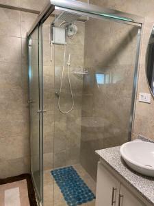 a shower with a glass door in a bathroom at Hospedaje en Quito Norte, Apartamento & Suite independientes in Quito
