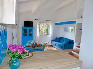 a living room with a table and a blue couch at Résidence Belvedere de Palombaggia in Porto-Vecchio