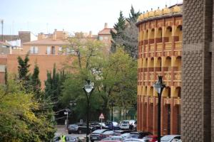 um parque de estacionamento com carros estacionados ao lado de um edifício em Amplio apartamento Plaza de Toros em Zaragoza