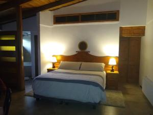 een slaapkamer met een groot bed met 2 lampen bij Willy's Country Club Cauquenes in De Cauquenes