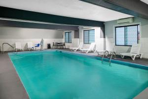 una gran piscina con sillas y una mesa en Baymont by Wyndham Pooler/Savannah, en Savannah