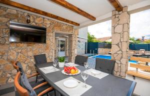 a dining room with a table and a stone wall at Apartman Genova Imotski in Donji Vinjani