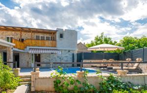 a house with a swimming pool in front of it at Apartman Genova Imotski in Donji Vinjani