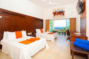 a hotel room with two beds and a balcony at Princess Mayev in Santa Cruz Huatulco