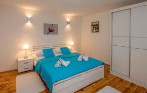 a bedroom with a large blue bed with blue pillows at Apartman Genova Imotski in Donji Vinjani +18 photos