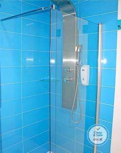 a shower stall with a blue shower curtain at Vivacity Porto - Rooms & Apartments in Porto
