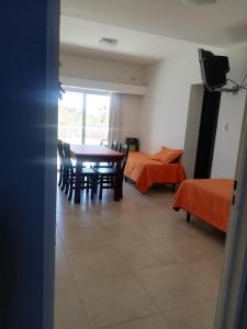 a room with a table and chairs and a bedroom at Departamentos LG in Las Grutas