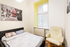 a bedroom with a bed and a chair and a window at Mrówka in Krakow