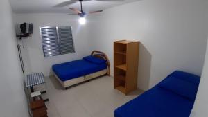 um pequeno quarto com 2 camas e uma janela em Sala-living/ 1 quadra da praia em Santos