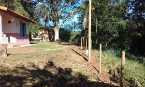 a yard with a fence next to a house at Chalés na fazenda in Santo Antônio de Posse