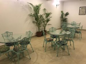 un comedor con mesas, sillas y plantas en BaywoodGoa, en Morjim