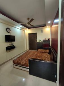 a bedroom with a bed and a flat screen tv at Shonar Kutir in Puri