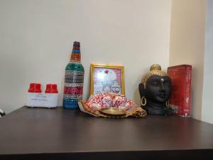 a shelf with a bottle of alcohol and a statue at Shonar Kutir in Puri