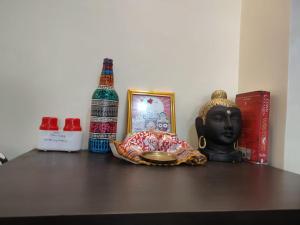 uma prateleira com uma garrafa de álcool e uma estátua em Shonar Kutir em Puri