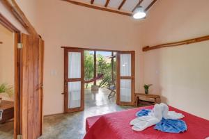 1 dormitorio con 1 cama con colcha roja en Casa Lajagua en Pedasí Town
