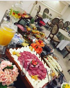 une table contenant de nombreux types de denrées alimentaires différents dans l'établissement Golden Lis Hotel Boutique, à Goiânia