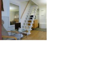 ein Wohnzimmer mit einer Treppe und einem Tisch in der Unterkunft Studio Fabert in Paris