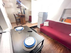 un soggiorno con tavolo e divano rosso di Stella Marina Appartamento a Cagliari