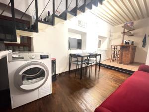 a living room with a washing machine and a table at Stella Marina Appartamento in Cagliari