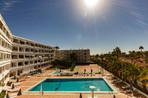 un hotel con piscina di fronte a un edificio di Seaview Friendly Holiday Home 5 a Playa del Ingles